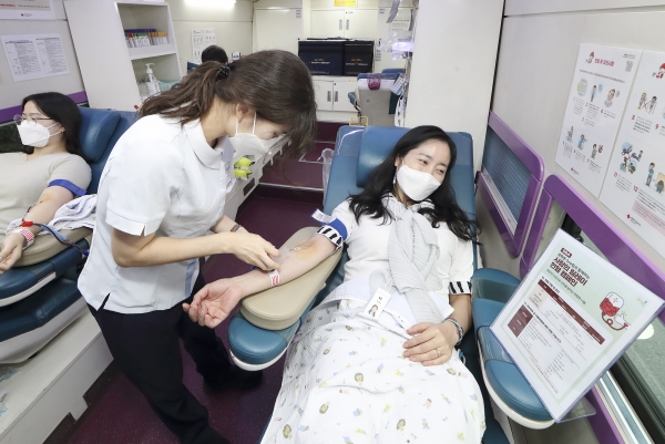 광화문원팀 소속 임직원이 대한적십자사 헌혈버스에서 헌혈을 하고 있다